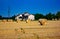 Background. lowland landscape with farm. field with bales of harvested hay.