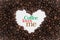 Background made of coffee beans in a heart shape with message `Coffee loves me`