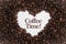 Background made of coffee beans in a heart shape with message `Coffee Time!`