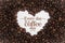 Background made of coffee beans in a heart shape with message `Every day is a coffee day`