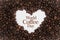 Background made of coffee beans in a heart shape with message `World Coffee Day`