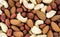 Background from a mixture of four types of nuts: cashews, peanuts, hazelnuts, and almonds