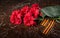 On the background of the monument, a bouquet of red carnations, military cap and St. George ribbon, close-up