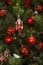 Background from natural and artificial pine branches with an old Nutcracker toy, figurines, cones and red balls