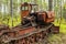 Background old rusty abandoned tractor standing in the woods