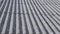 Background of old wavy slate sheets mounted on village house rooftop