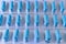 Background of packaged blue medical capsules. Manufacture of medicines and vitamins. Soft focus