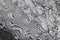 Background with pattern of damask steel. Close up. Macro shot of a damascus knife blade texture. Damascus steel pattern. Metal and