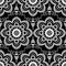 Background pattern with white mehndi seamless lace decoration items on black background.