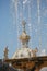 Background photo: view of the dome of the Special Pantry behind the fountain jets on a sunny day. Peterhof