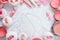 Background with pink beauty products like cute powder puffs with ribbons, blush pots, makeup brushes