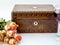 Background with pink dried roses, antique walnut jewelry box wit