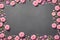 Background with pink flowers on grey slate textute. Top view, copy space