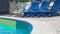 Background In the pool, loungers for rest and relaxation on the side of the refreshing blue pool.