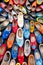 Background of Popular souvenirs - Old wooden Dutch shoes - klomps. A lot of colorful old clomps against the background of a wooden