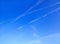 The background is pure blue sky with soft transparent clouds. Trace of the plane.