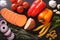 Background of raw vegetables: sweet potatoes, peppers, tomatoes, onions, garlic, rosemary and spices. Horizontal top view