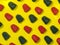 Background of red and black chewy candies in the form of berries on a yellow background. Sweets in the form of raspberries .