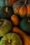 Background of red and green pumpkins on dark wood