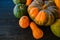 Background of red and green pumpkins on dark wood