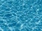 Background of rippled pattern of clean water in a blue swimming pool