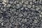 Background from a round dark gray stone. Dark pebbles closeup folded.