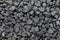 Background from a round dark stone. Dark pebble coal closeup folded.