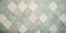 Background with small diamond shaped light teal blue and cream colored tiles