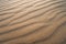 Background with smooth lines of sand. Sand dunes Ripples in the sand. Strips in the sand from the wind