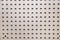 The background of the sound-absorbing plate is gray with solid perforations in the form of holes, construction, texture