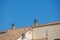 Background with spanish tiled roofs of houses against a cloudless blue sky