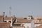 Background with spanish tiled roofs of houses against a cloudless blue sky