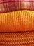 Background of a stack of knitted pink and orange sweaters