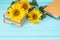 Background with sunflowers and yellow book on blue wooden boards