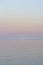 Background of a sunset by the sea with a red plastic buoy floating on the calm water in portrait format