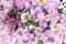 Background of tea rose petals with flowers of daisies, violets