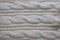 Background textile white knitted plaid of thick woolen yarn white knitted plaid