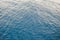 Background texture of a calm deep blue ocean with ripples on the surface of the seawater, full frame