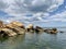 Background texture: large stones of various shapes in the sea. A pile of granite boulders against the background of the sea and