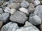 Background texture: many large stones of different shapes. A pile of granite boulders. Concept - stone, hardness, foundation