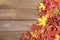 Background texture with old wooden table and yellow autumnal fallen maple leaves