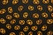 Background texture of salted savory mini pretzels in the traditional looped knot shape on the black background