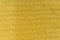 Background, texture of striped knitted fabric colors ocher yellow with lurex