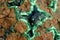 Background, texture: surface of a block of copper ore with veins and geodes of malachite