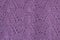 Background texture of violet pattern knitted fabric made of cotton or wool closeup