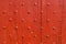 Background texture weathered red wooden door with nail decoration