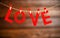 Background Valentine`s day. two red hearts and word Love on wooden