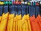 Background of Various Sizes of Yellow and Orange T-Shirts on Hangers