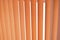 Background of vertical orange blinds curtains. Pleated roller blinds. Orange striped background
