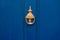 Background of vintage blue painted door and knocker vignette look made of old fashioned vintage brass metal